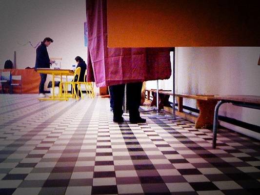 Photographie d'un homme dans un isoloir lors des élections régionales 2014