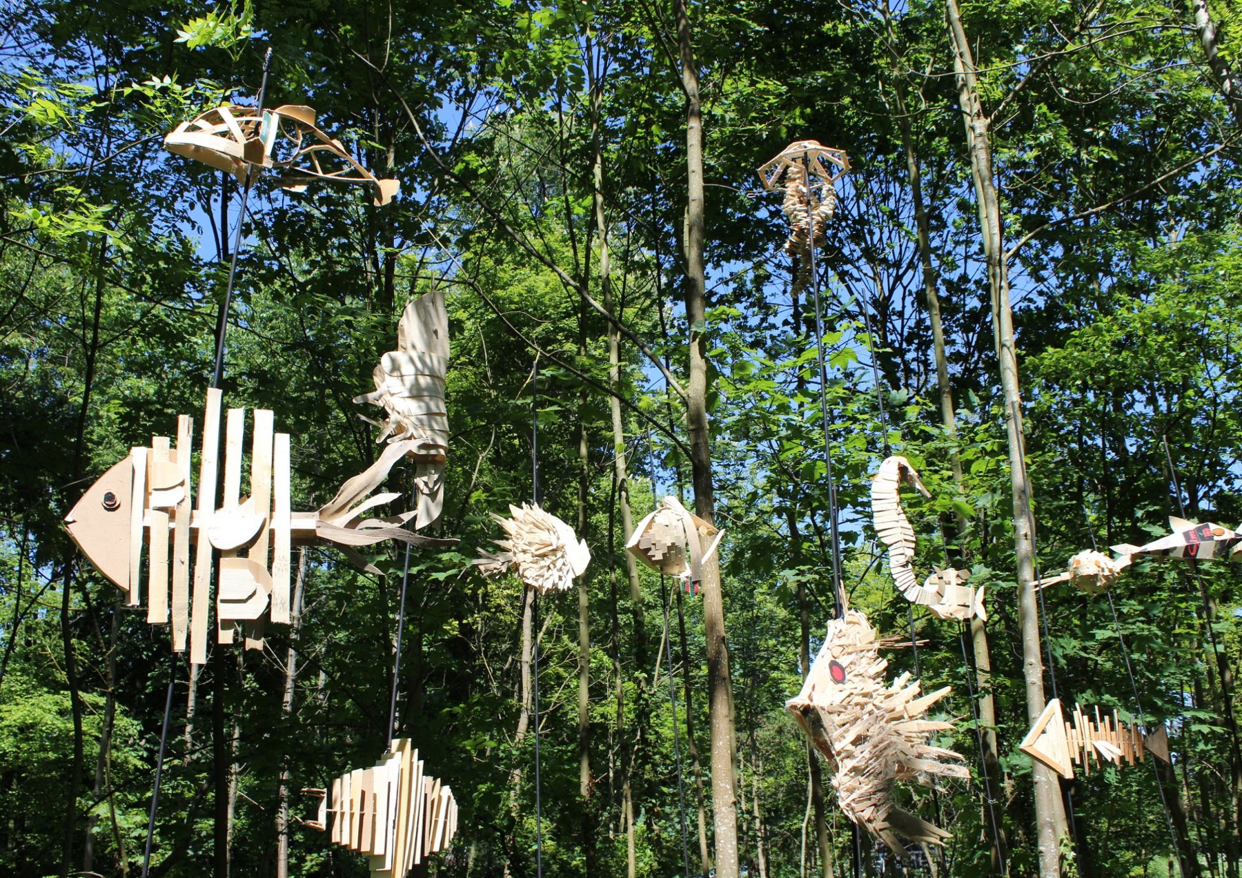 Installation formant une vague composée d'une centaine de monstres marins imaginaires réalisés en cagettes recyclées