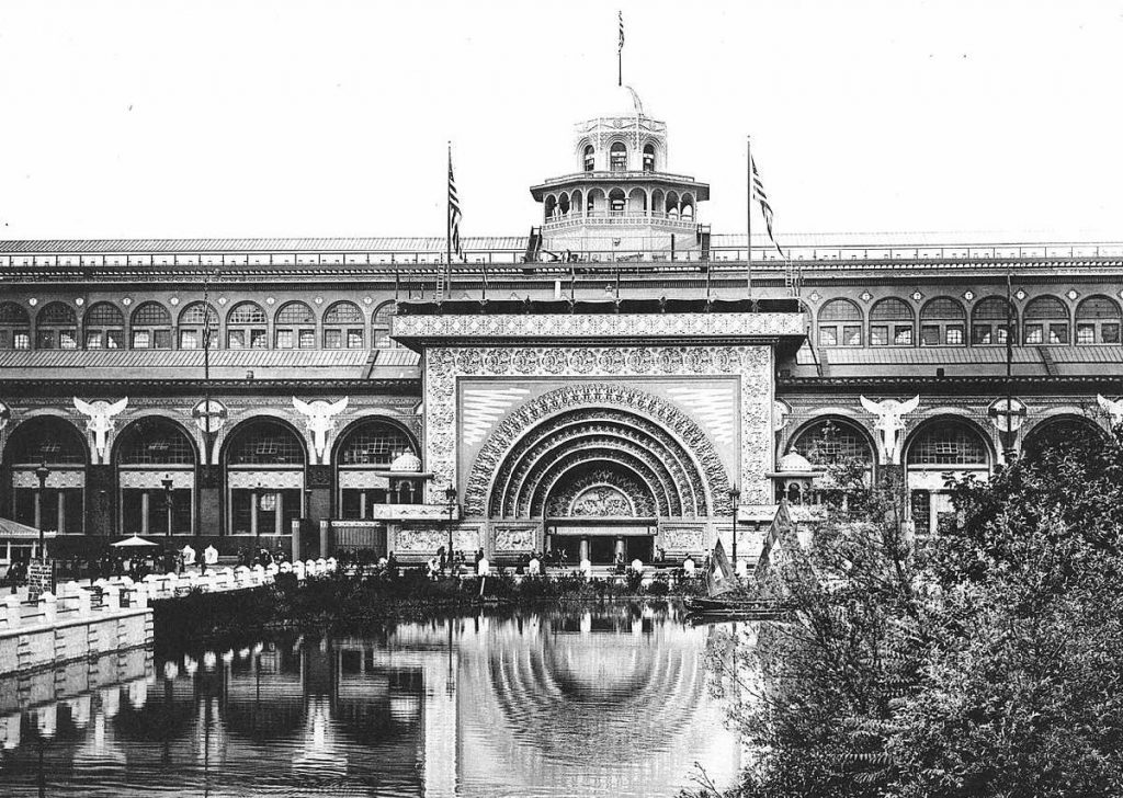 Photographie en noir et blanc du Transportation Building : une porte avec arche centrale surmontée d'une coupole, et un bassin au premier plan
