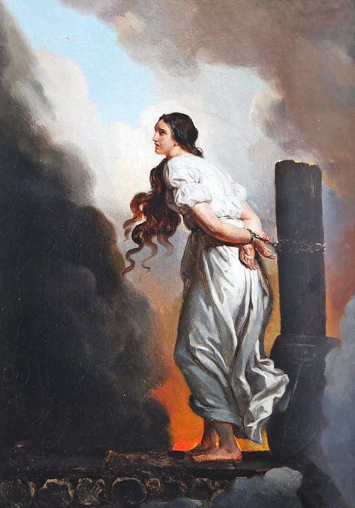 une jeune femme à la robe blanche et aux longs cheveux bruns, attachée à un bûcher, autour de laquelle s'accumule de la fumée noire