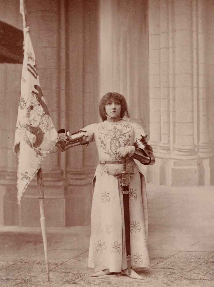 Photographie de Sarah Bernhardt costumée en Jeanne d'Arc, en armure, avec étendard