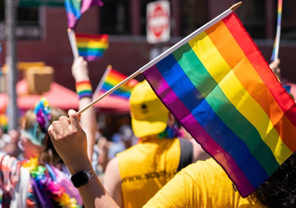 Drapeau et accessoires arc-en-ciel affichés lors d'une Gay Pride
