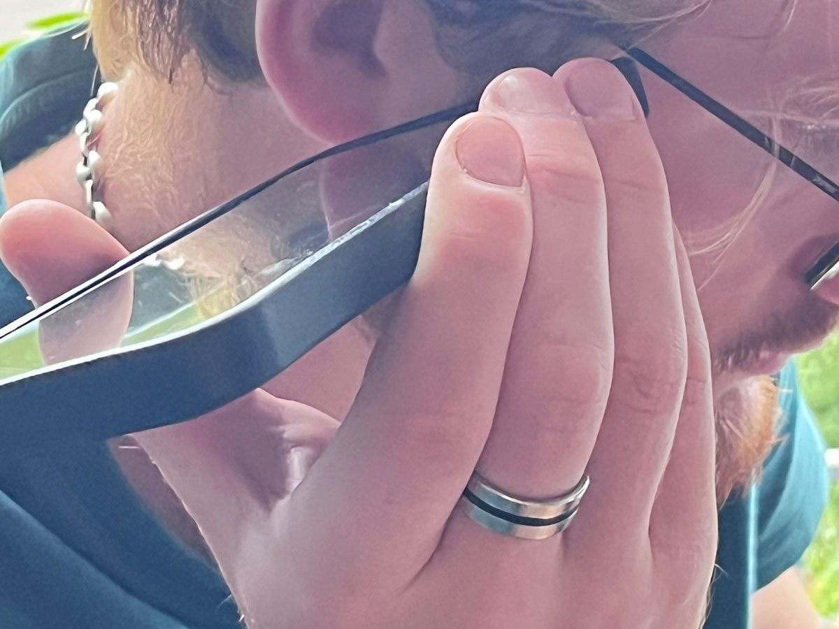 un jeune homme écoute un vocal en portant son téléphone à l'oreille. 