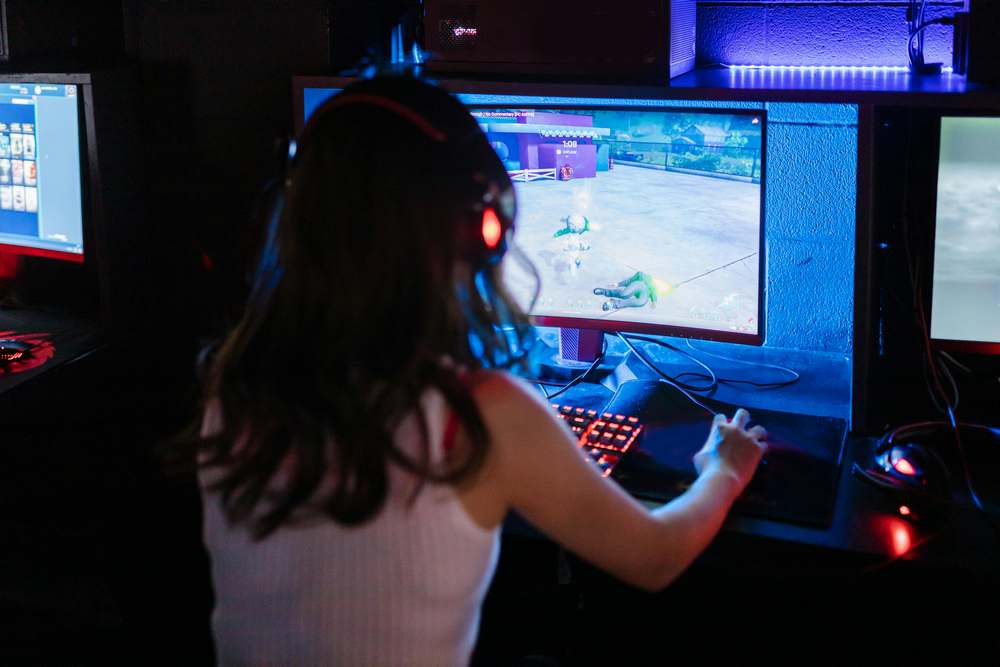 Femme de dos jouant à un jeu vidéo