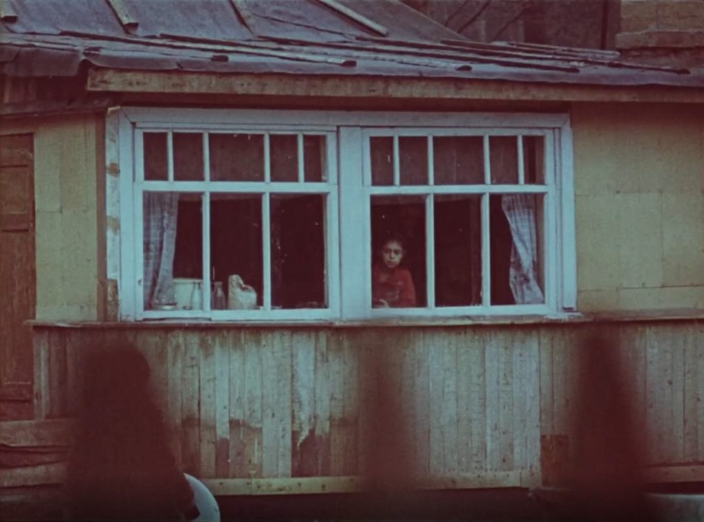 Un garçon regarde par la fenêtre