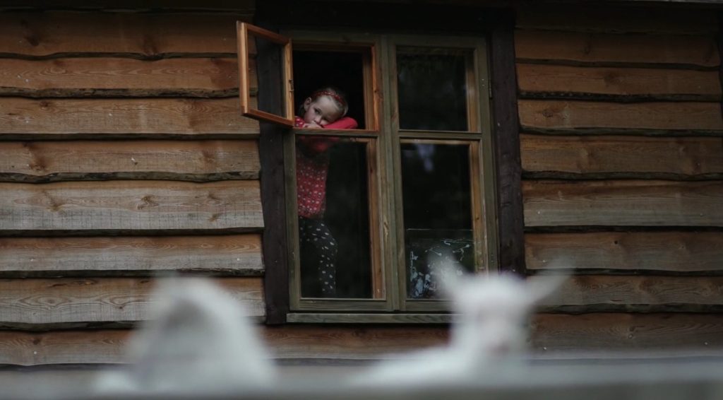 Une fillette regarde par la fenêtre