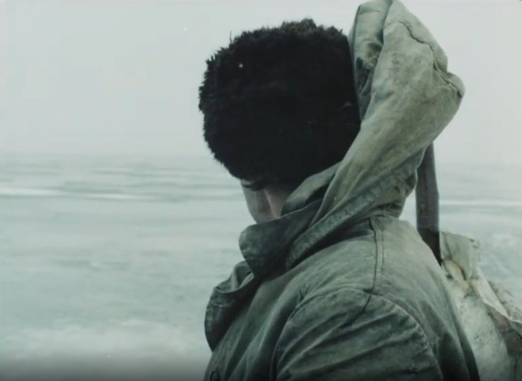 Un homme au bonnet de profil regarde la mer
