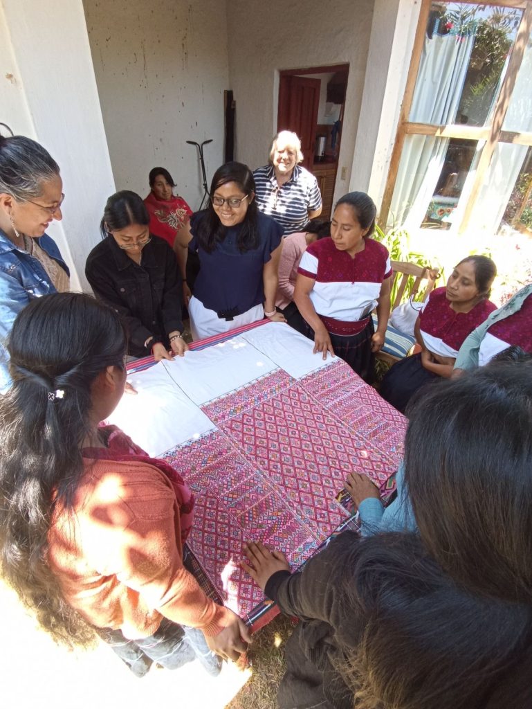 Des femmes sont réunies autour d'un huipil