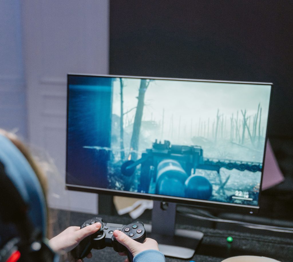 Une personne vue de dos joue à un jeu vidéo sur la guerre