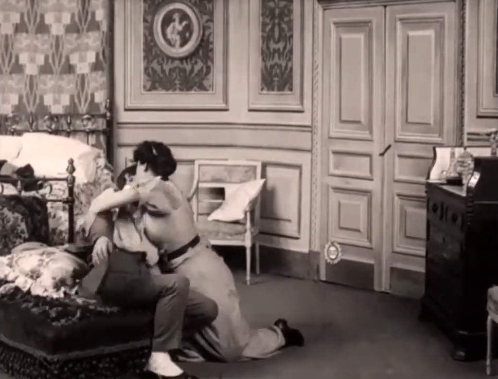 Une femme déshabille un homme près d'un lit