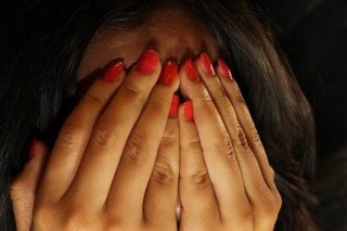 photo d'une femme se cachant le visage avec ses mains