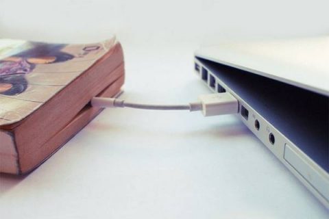Photo d'un livre relié par un câble à un ordinateur