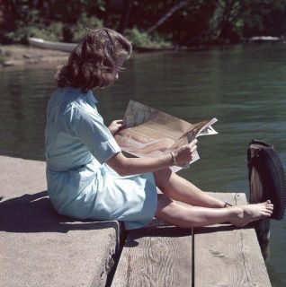 Femme lisant au bord d'un lac