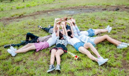 Groupe de jeunes allongés sur l'herbe en forme de cercle