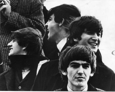 Les Beatles, dehors, souriants dans quatre directions