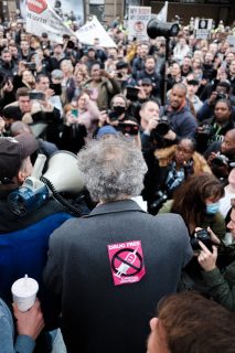 Photo de manifestants anti-vaccin à Londres, au premier plan un homme de dos avec un autocollant "Drug free"