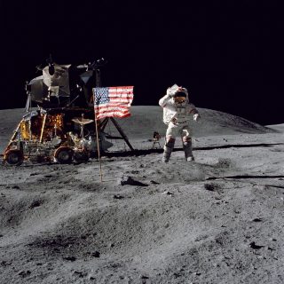 Charles M. Duke, commandant de la mission Apollo 16, John W. Young, salue le drapeau des États-Unis planté sur la Lune.