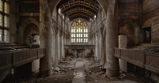 L'intérieur d'une église. Le sol est jonché de bois, la nef est déserte.
