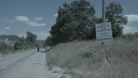 Sur une route de campagne déserte, un panneau souhaite la bienvenue aux États généraux du film documentaire de Lussas.