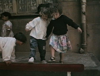 Deux petites filles se tiennent par la main, en montant sur un banc.