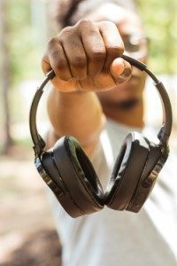 Un homme tend un casque audio devant l'objectif