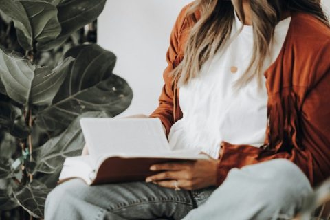 Jeune femme lisant un livre, gros plan sur ses mains