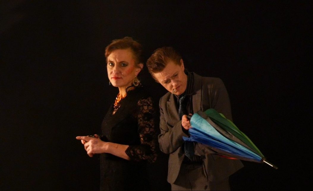 Photogramme du film. Deux personnes, face à l'objectif, sur fond noir.