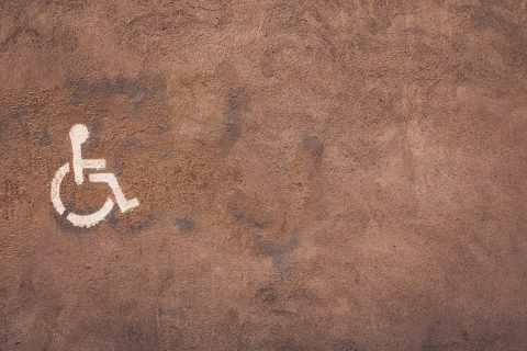 photo d'un mur avec un marquage au pochoir représentant le pictogramme d'une personne en fauteuil roulant